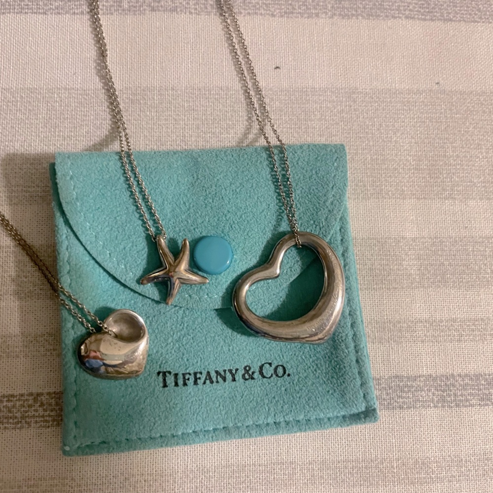 Three Tiffany & Co pendants with chains.